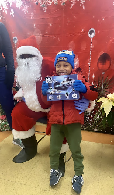 little boy smiling with Christmas gift and Santa